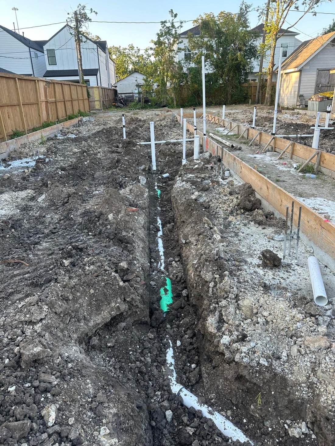 Línea de drenaje sanitario verde en zanja de construcción nueva